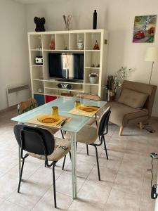 ein Wohnzimmer mit einem Glastisch und Stühlen in der Unterkunft La Riviere du les jarden de Elisa in Beausoleil