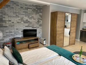 a living room with a brick fireplace and a bed at Apartament Blue Lagoon in Sopot