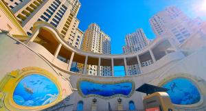 a building with a large aquarium with tall buildings at The W Jumeirah Beach in Dubai
