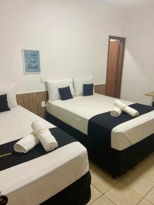 una camera d'albergo con due letti e asciugamani di HOTEL ROCHA - Olímpia a Olímpia