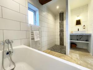 un bagno bianco con vasca e lavandino di L'Echappée au Gué - Nordic bath a La Fontenelle Altre 43 foto