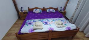ein Schlafzimmer mit einem Bett mit einer lila Bettdecke in der Unterkunft Etno smeštaj Stojadinović in Svrljig