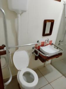a bathroom with a white toilet and a sink at Pousada Estância Mineira in Campo Grande