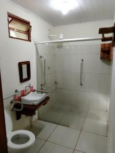 a bathroom with a shower and a toilet and a sink at Pousada Estância Mineira in Campo Grande
