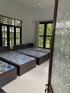 een kamer met 4 bedden en ramen bij Nature homes in Moratuwa