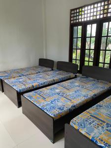 3 Betten in einem Zimmer mit Fenstern in der Unterkunft Nature homes in Moratuwa