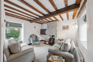 a living room with two chairs and a fireplace at 1 The Barn - Brassington in Brassington