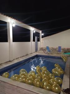 a swimming pool with a bunch of green balloons in it at Pousada Casarão in Cruzília