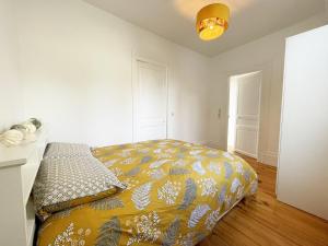 um quarto com uma cama com um cobertor amarelo em The Châtelet em Chartres