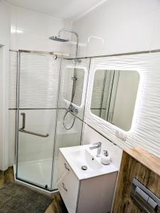 a white bathroom with a shower and a sink at Apartament Leomar, bezkontaktowe zameldowanie, darmowy parking in Poznań