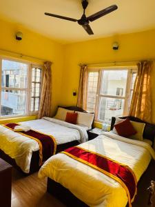 1 dormitorio con 2 camas y 2 ventanas en Hotel The Billabong Garden Pokhara en Pokhara