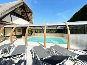 a deck with chairs and a swimming pool at Souvenirs en campagne in Sours