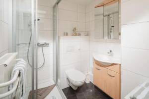 a white bathroom with a toilet and a shower at Aurora in Norderney