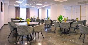 una sala de conferencias con mesas y sillas con plantas en SIR FUNDENI HOTEL, en Bucarest