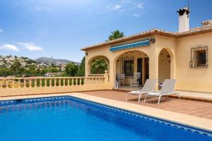 a villa with a swimming pool and a house at Villa Escudero - Plusholidays in Calpe