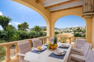 a dining room with a table and chairs on a balcony at Villa Escudero - Plusholidays in Calpe