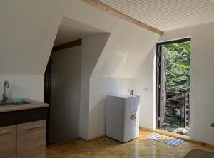 a white refrigerator in a kitchen with a window at Дикий Ліс in Yaremche +24 photos