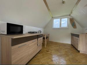 an attic kitchen with a microwave and a table at Дикий Ліс in Yaremche