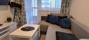 a living room with a couch and a table at Apartament Morski in Koszalin
