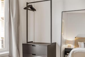 eine Kommode mit einem Spiegel im Schlafzimmer in der Unterkunft Flott leilighet i hjerte av Oslo in Oslo