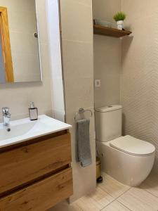 a bathroom with a white toilet and a sink at Villa Costa Antigua Piscina in Costa de Antigua