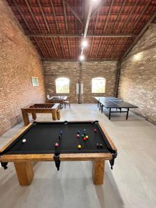 a pool table in a room with two ping pong tables at Rancho da Cachaça Pousada in Holambra