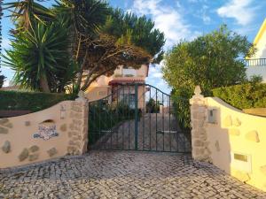 a gate in front of a house with trees at Villa Terra da Eira-Sea view in Lourinhã