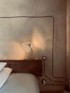 1 dormitorio con 1 cama con lámpara en la pared en Gite Drôles d'Oiseaux, en Plieux