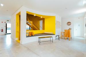 a living room with a yellow wall and a table at Surf & Sea Suites in Parede