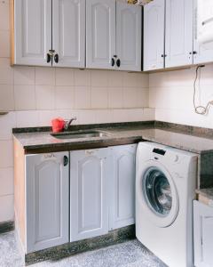 a kitchen with a sink and a washing machine at HOSTEL La Casa de Li - En in Chilecito