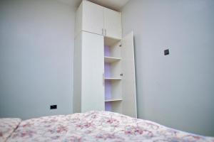 a bedroom with a bed and a white cabinet at ATA Lux Apartments in Kira