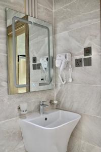 a bathroom with a white sink and a mirror at SUN SET HOTEL فندق سن ست in Najran