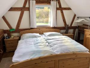 ein großes Bett in einem Zimmer mit Fenster in der Unterkunft Eschachblick in Zimmern ob Rottweil