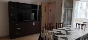 a dining room with a table and a television on a cabinet at Dpto Ariel in Mar del Plata
