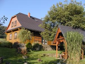 uma grande casa de madeira com um telhado de gambrel em Jesenická Chalupa 