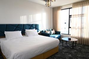um quarto de hotel com uma cama grande e um sofá em SUN SET HOTEL فندق سن ست em Najran