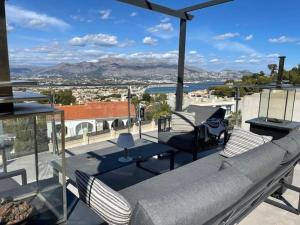 a patio with a couch and chairs on a roof at Magnificent view and pool in Albir