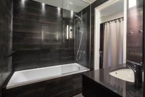 a bathroom with a tub, sink and shower at Lapland Hotels Oulu in Oulu
