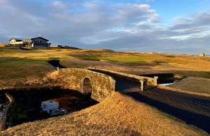 a stone bridge over a pond on a golf course at Blue Viking Studios in Keflavík