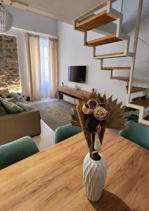 ein Wohnzimmer mit einem Tisch und einer Vase mit Blumen in der Unterkunft CLASSY HOMES - Acquamarina in Sanremo
