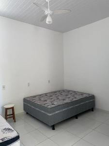 a bed in a room with a ceiling fan at Casa em Ubu in Anchieta