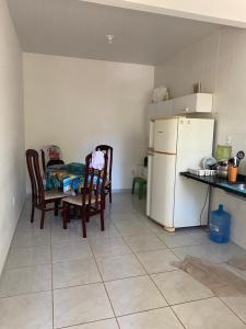 a kitchen with a table and chairs and a refrigerator at Casa em Ubu in Anchieta