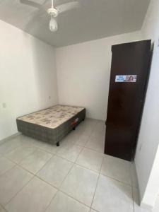 a room with a bed in the corner of a room at Casa em Ubu in Anchieta