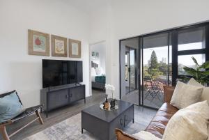 a living room with a couch and a tv at Atlantic Port 9 in Bloubergstrand