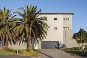 a palm tree in front of a building with a garage at Atlantic Port 9 in Bloubergstrand
