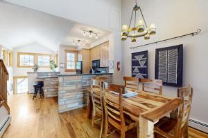 cocina y comedor con mesa de madera y sillas en Granby Grandeur, en Granby