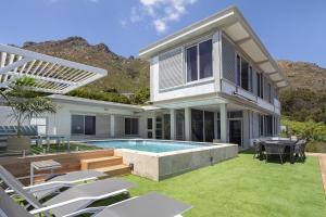 a house with a backyard with a swimming pool at Atlantic Sky Villa in Gordonʼs Bay