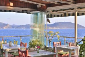 a restaurant with tables and chairs and a view of the ocean at Hotel Sonne - Adults Only in Kaş