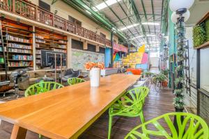 una mesa de madera en una biblioteca con sillas verdes en OYO 965 Art Hotel Sanamchai, en Bangkok