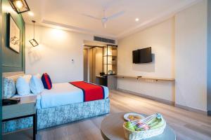 a hotel room with a bed and a table at Spree Hotel Kriday Dehradun in Dehradun